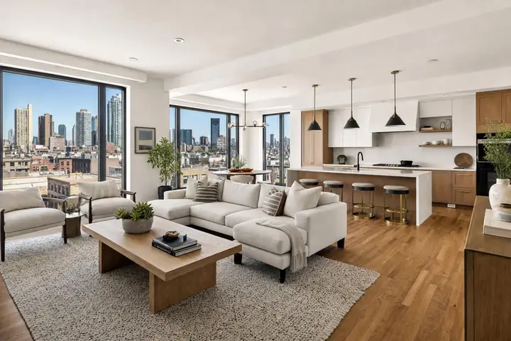 Sunny living room with large windows, modern furniture, and hardwood floors, highlighting bright real estate photography