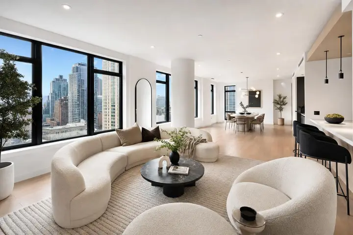 Spacious luxury apartment interior with modern furniture and large windows showcasing a NYC skyline view.
