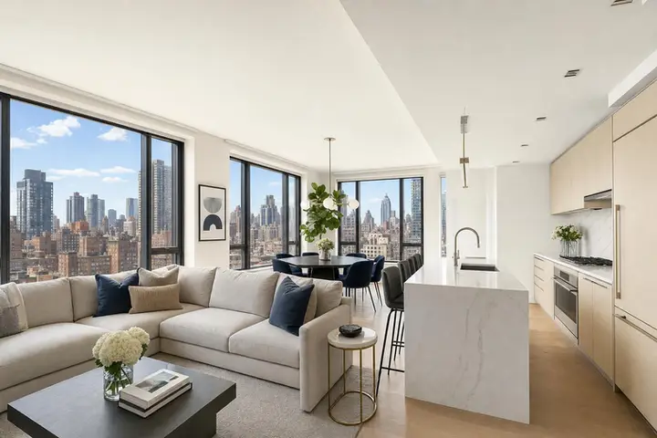 Modern NYC apartment interior with large windows, hardwood floors, and contemporary furnishings in natural daylight
