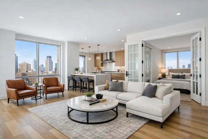 Modern open-concept NYC apartment with city views, featuring a cozy living area, stylish kitchen, and inviting bedroom.