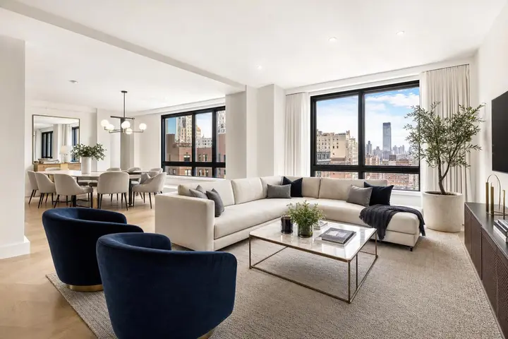 Modern living room with large windows, stylish furniture, and cityscape view highlighting real estate photography NYC style