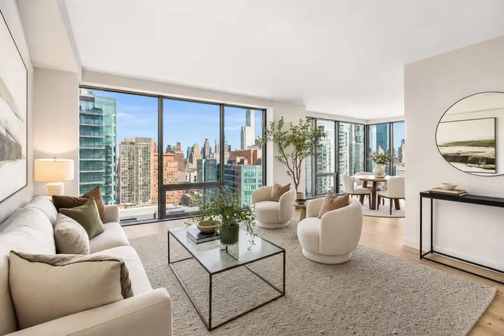 Modern, spacious living room with large windows, stylish furniture, and city views, ideal for real estate photography