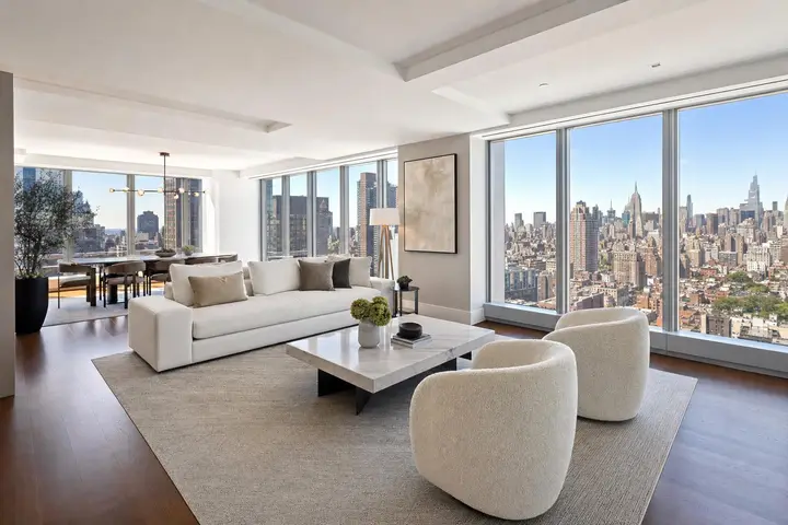 Luxurious modern living room with floor-to-ceiling windows showcasing a panoramic view of the New York City skyline.