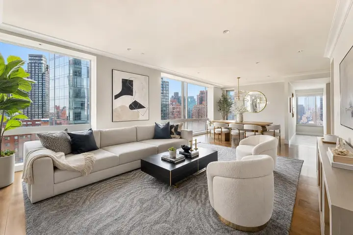 Brightly lit modern living room with large windows, stylish furniture, and city views, ideal for Manhattan real estate photographer