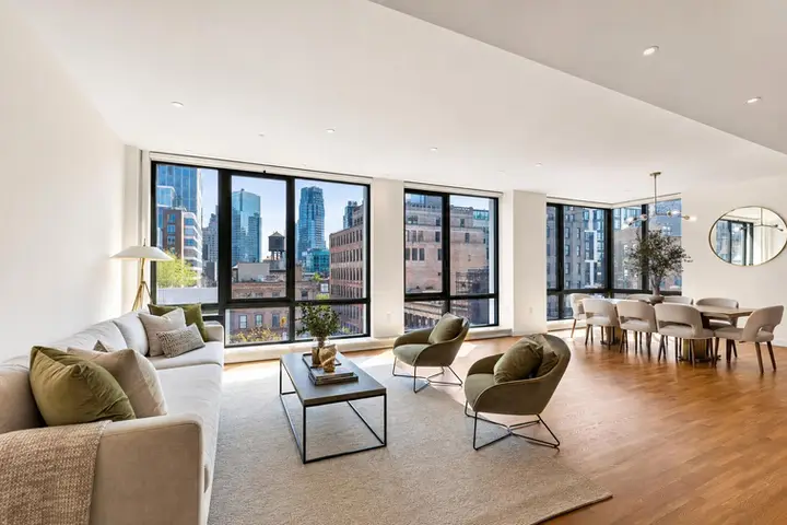 Bright, modern living room with large windows, stylish furnishings, and city views, showcasing real estate photography services NYC