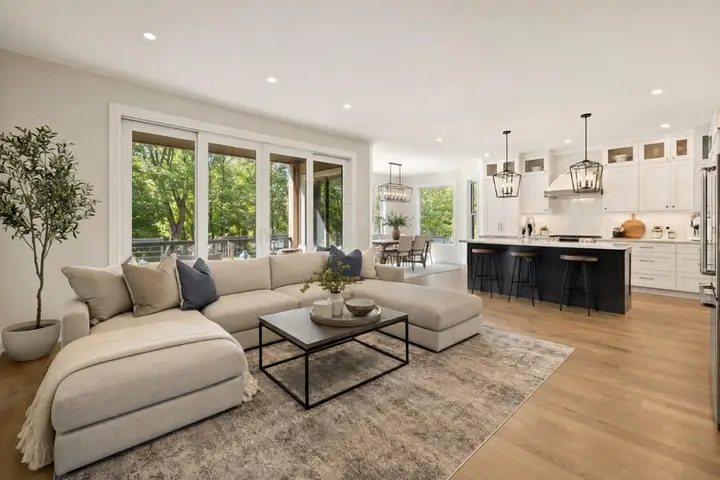 Bright modern living room with large windows, stylish furniture, and city views, ideal for real estate photography