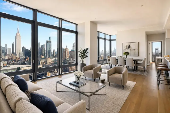 Modern living room with large windows, stylish furniture, and city views highlighting real estate photography services NYC