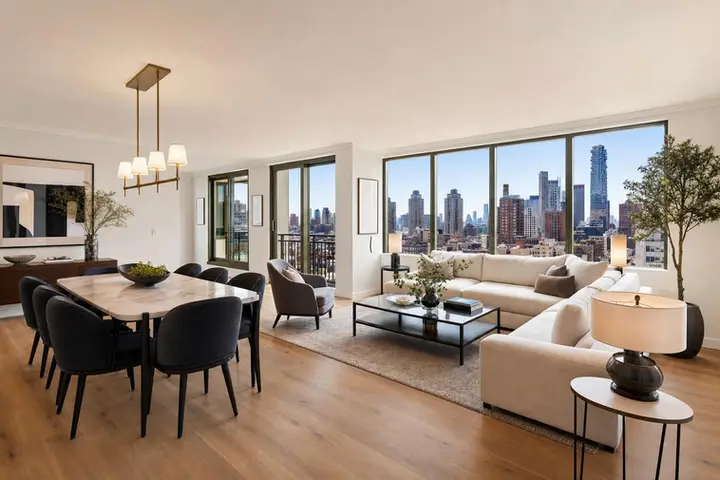 Modern living and dining area with skyline views, featuring elegant furnishings and large windows.