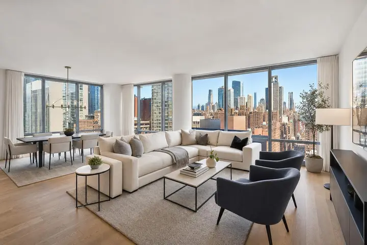 Modern living room with large windows, sleek furnishings, and bright natural light, showcasing expert real estate photography NYC