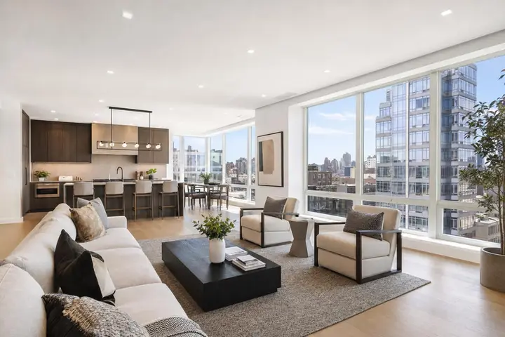 Bright modern living room with large windows, gray sofa, and wooden floor, ideal for a Zillow 3D tour comparison