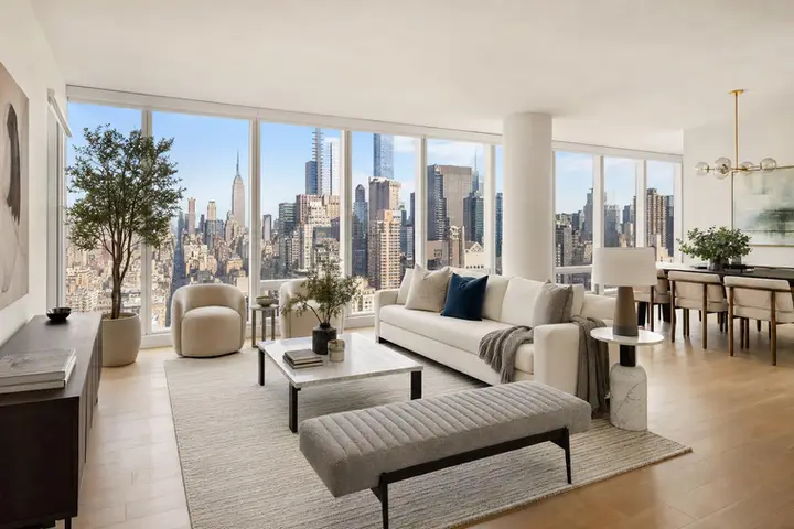 Elegant living room with modern decor and panoramic NYC skyline views through large windows.