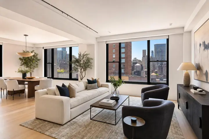 Bright and modern living room interior with large windows, stylish furniture, and city views, ideal for real estate photography company NYC