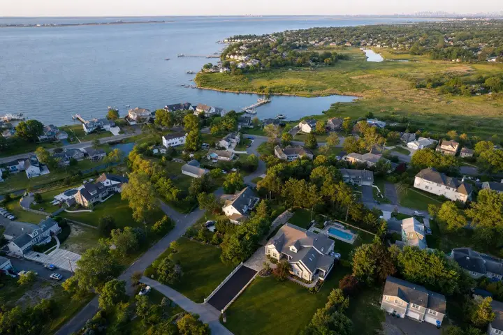 Aerial view of a suburban neighborhood in New Jersey with waterfront properties and lush greenery, showcasing drone photography NJ.
